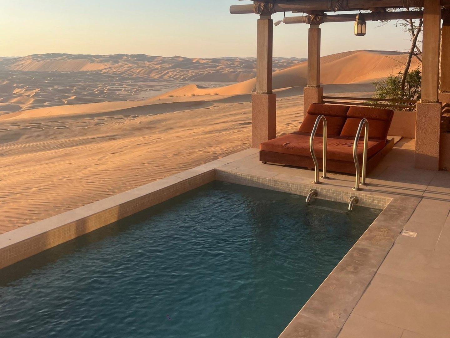 Private plunge pool and shaded daybed on a villa terrace at Bab Al Nojoum Bateen Liwa, facing the Liwa dunes at sunset